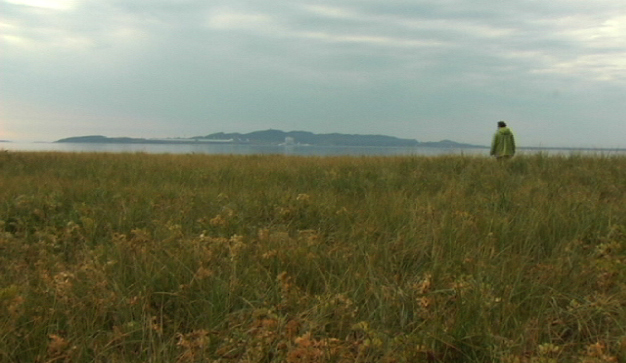 Anne-Marie André aux abords du fleuve à Uashat dans Aimer, finir, un film de Lucie Lambert